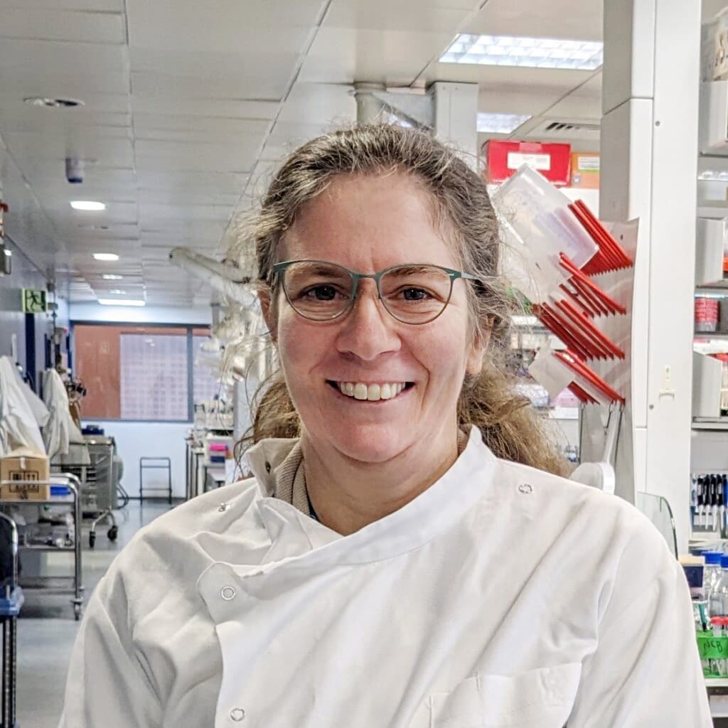 a woman wearing glasses and a chef coat