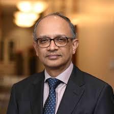 man in a suit and tie standing in a hallway, representing the professional image associated with EV magnet supply