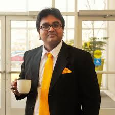 man in a suit holding a cup of coffee, showcasing a professional demeanor in the context of EV motor technology