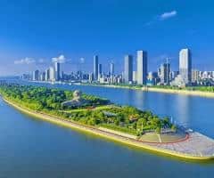 island in the middle of a river with a city in the background, showcasing deep-water environmental restoration efforts