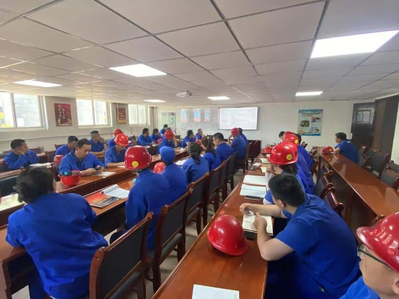 group of people sitting at desks in a classroom related to rare earth extraction security