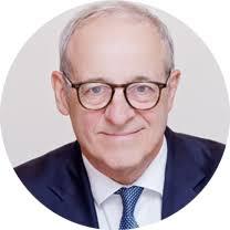 man in a suit and tie wearing glasses, representing the importance of rare earth supply chains