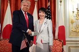 man and woman shaking hands in front of flags related to the U.S.-Japan critical minerals framework