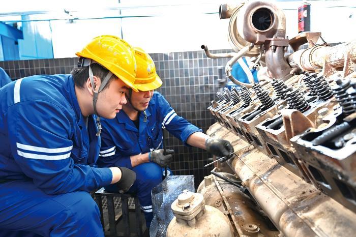 wo men in hard hats working on a machine in an industrial services expansion