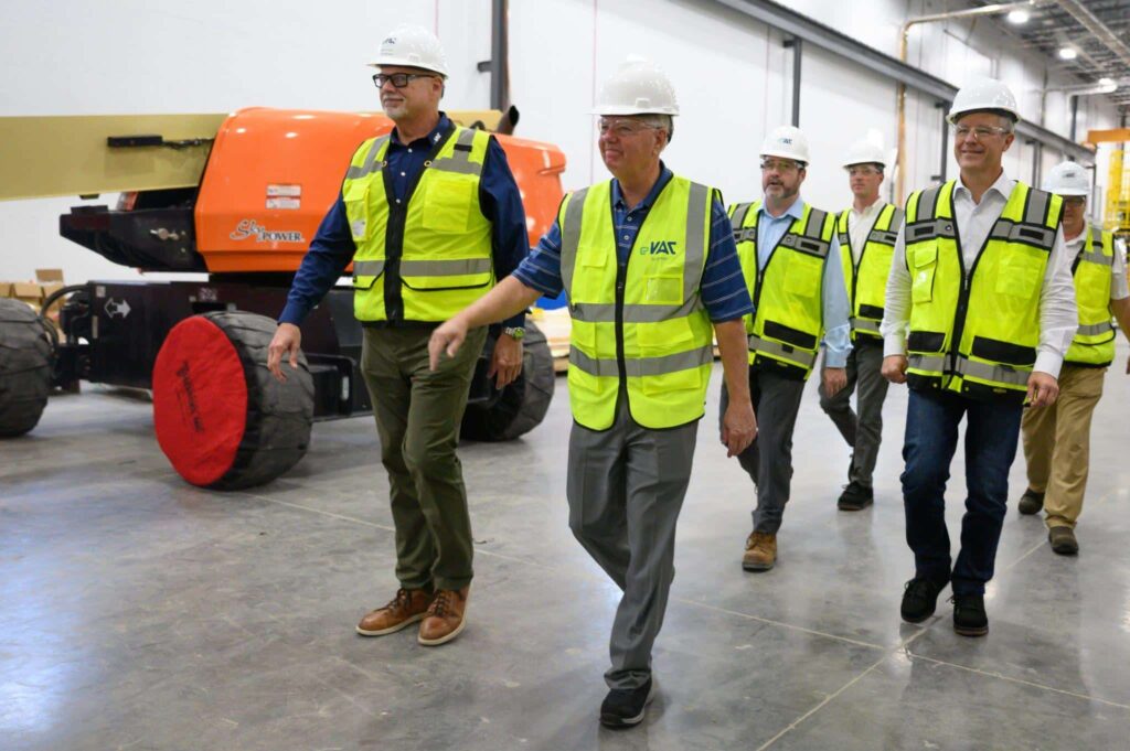 group of men in safety vests walking in a warehouse