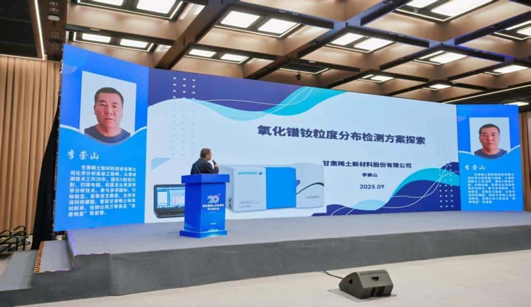 rare-earth-testing-1 man standing at a podium in front of a large screen discussing rare earth testing