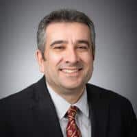 man in a suit and tie smiling, showcasing professionalism and confidence, relevant to switched reluctance motors