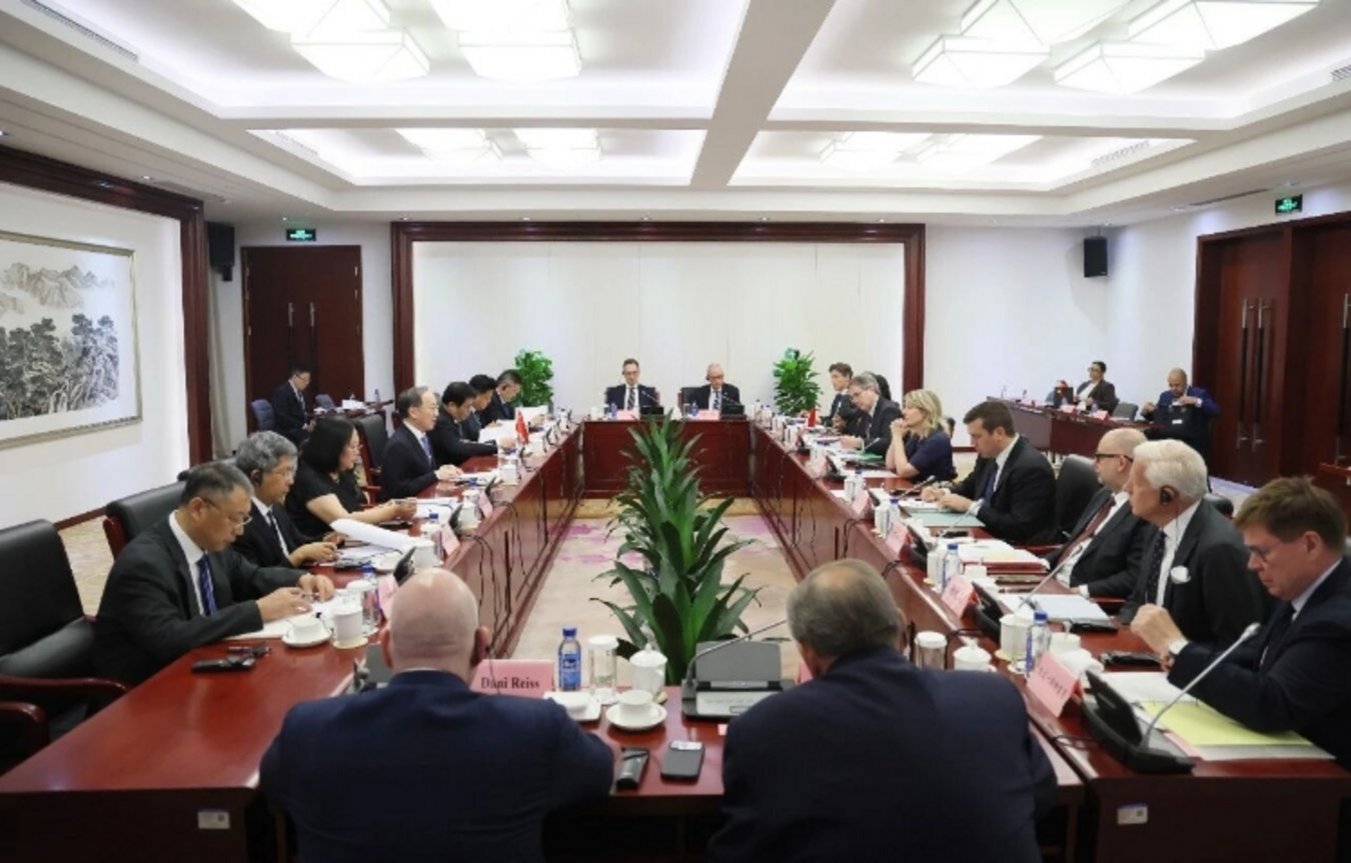 International delegation including Dani Reiss seated at large conference table during formal China-Europe bilateral business