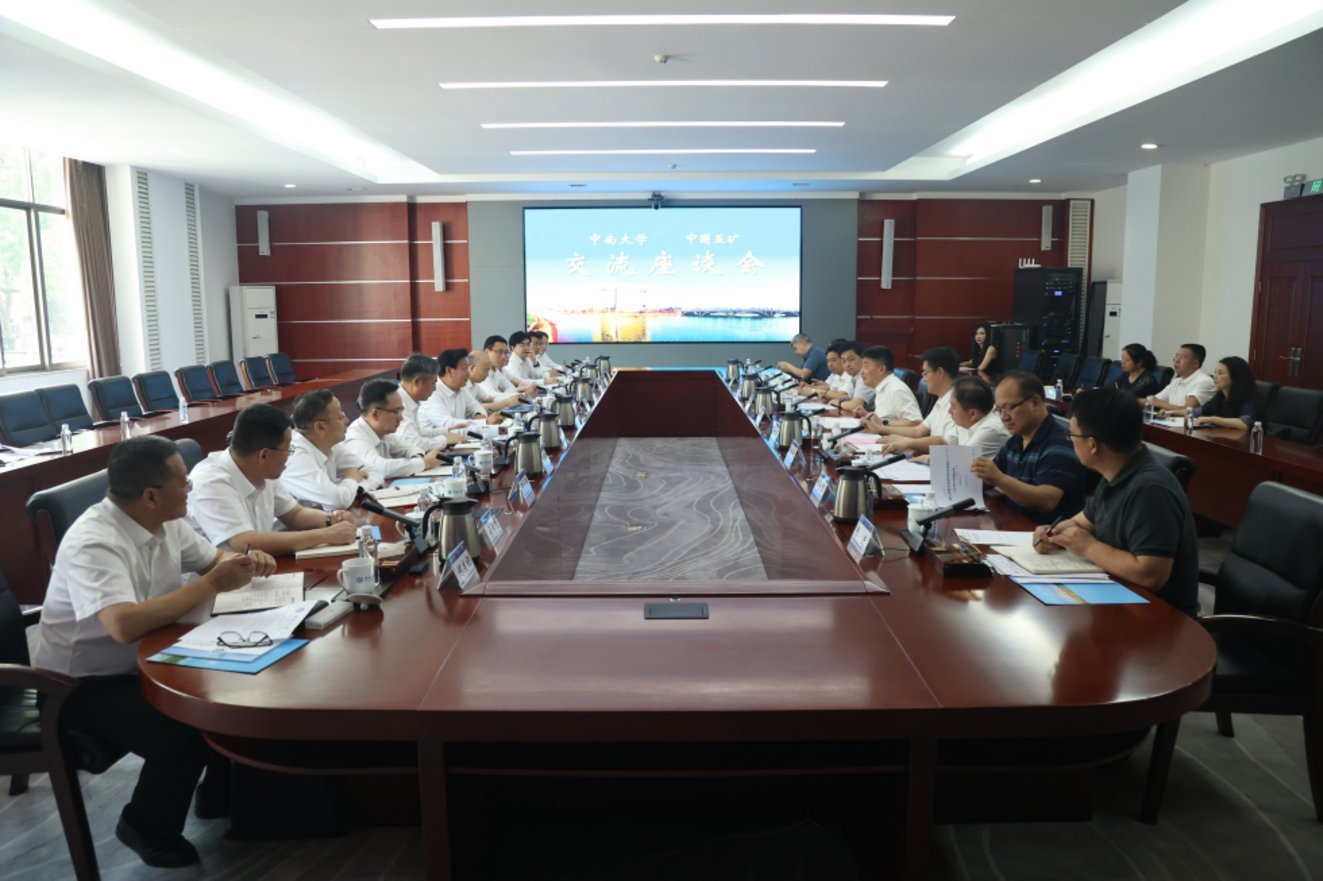 Delegates from Zhongnan University and Zhongguo Mining seated at large oval conference table during formal exchange symposium