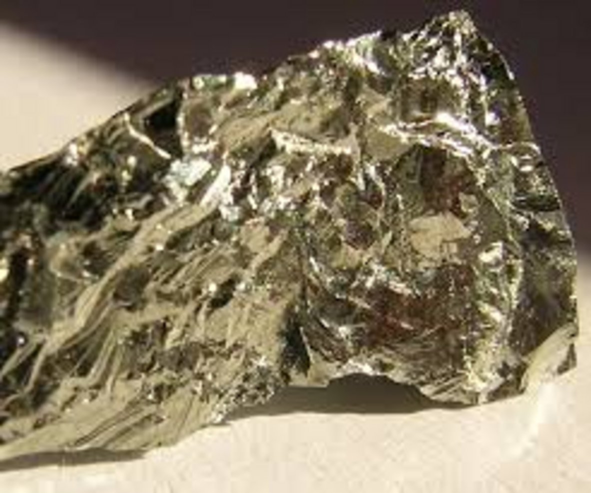 Raw bismuth native element mineral specimen with silvery metallic luster and irregular crystalline fracture surface on white