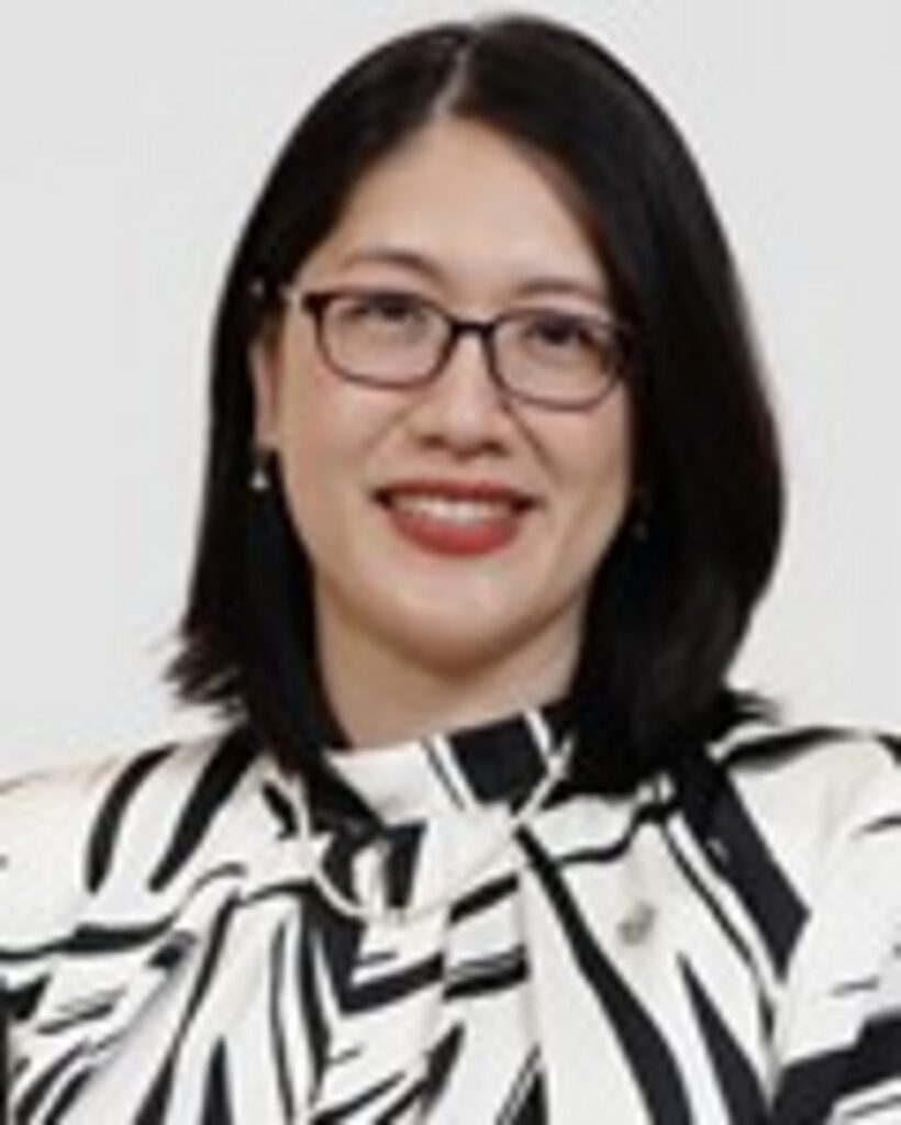 Smiling professional woman with black bob haircut, rectangular dark-framed glasses, red lipstick, wearing a black and white g