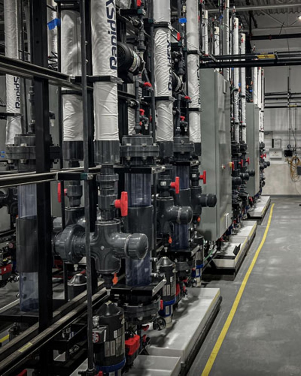 RapidSX branded solvent extraction columns with red-handled PVC ball valves, clear sight glasses, and motorized pump assembli