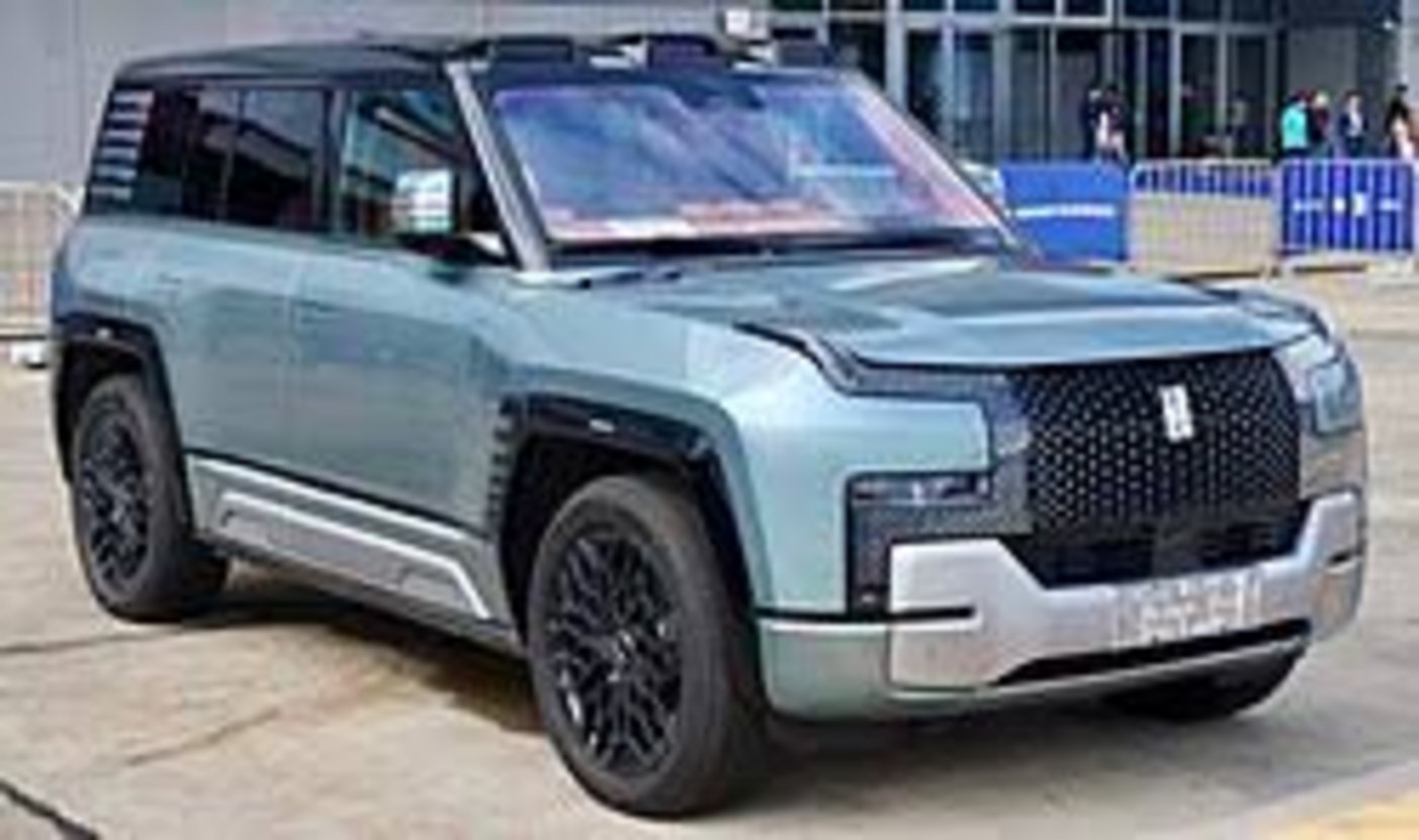 BYD Yangwang U8 electric luxury SUV in sage green with black mesh grille, roof rack, and black multi-spoke alloy wheels parke