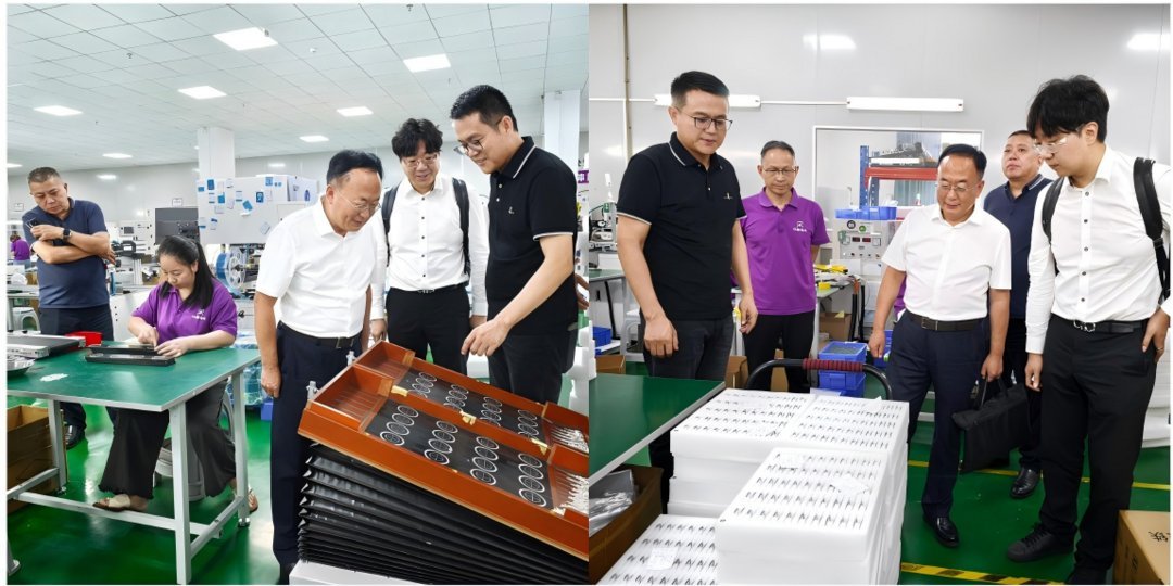 Group of business professionals in black and purple uniforms examining stacked PCB panels and printed documents at a clean ro