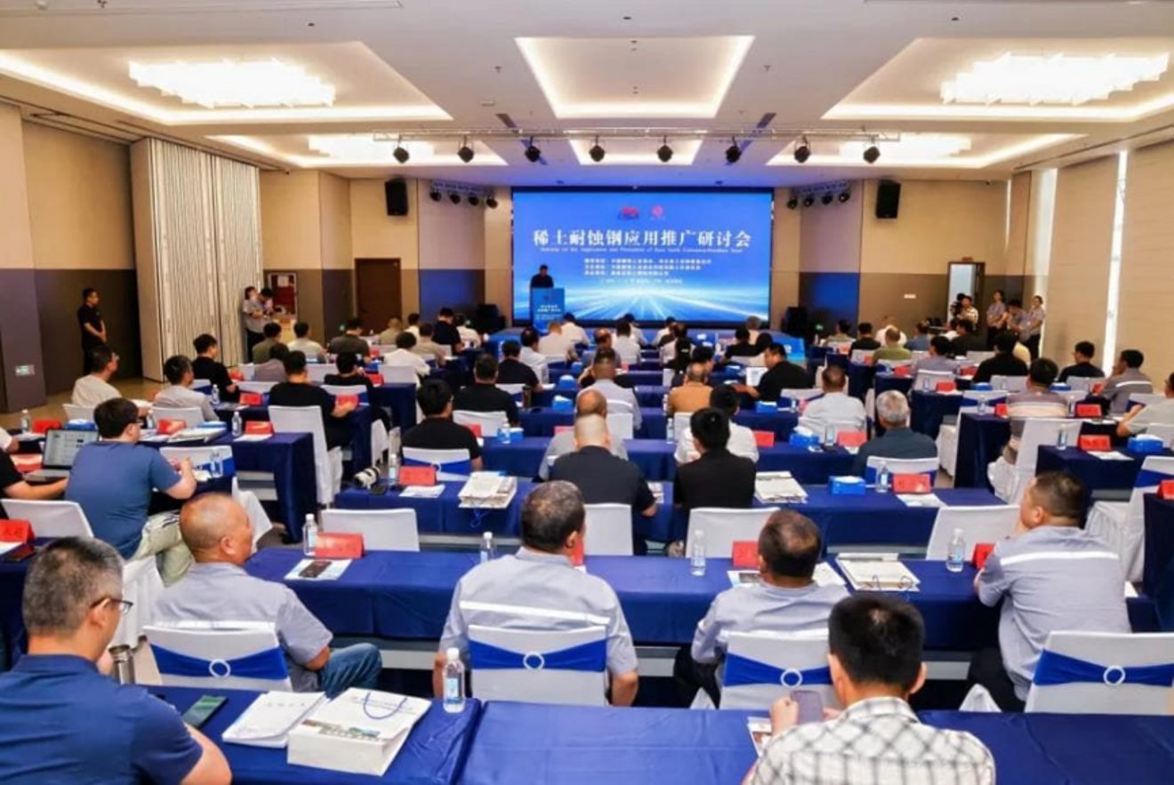 Attendees seated at blue-draped tables facing a presenter at podium during 稀土耐蚀钢应用推广研讨会 Rare Earth Steel Seminar in China
