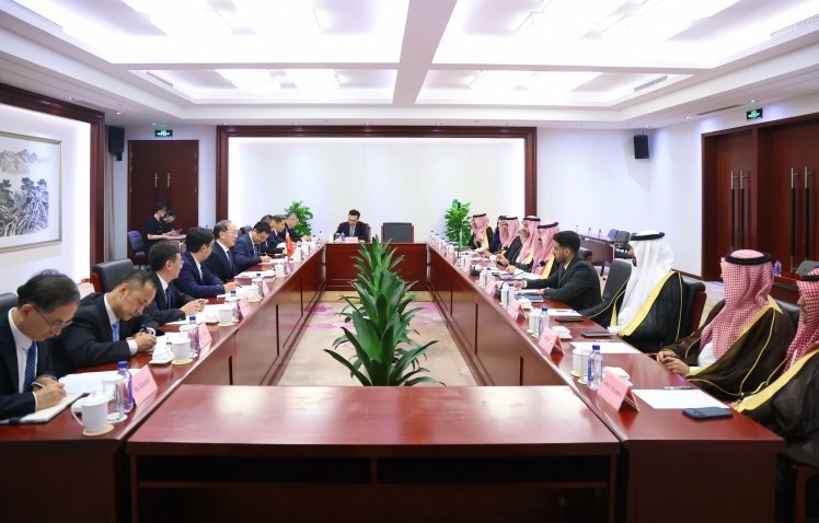 Chinese and Saudi Arabian government delegations seated at large rectangular conference table during formal bilateral diploma