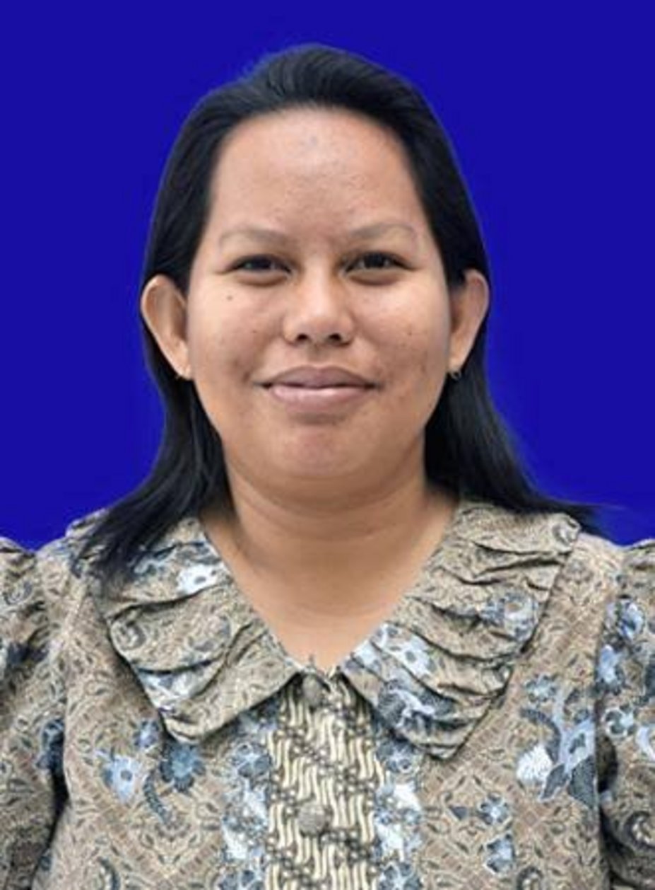 Southeast Asian woman with straight black hair wearing a brown and blue batik patterned blouse with ruffled collar, smiling