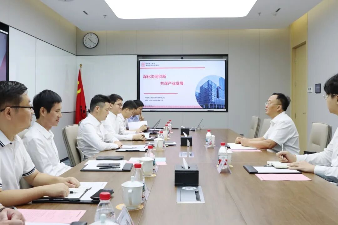 Corporate executives in white shirts at conference table reviewing 深化协同创新共谋产业发展 strategy presentation on projector screen in