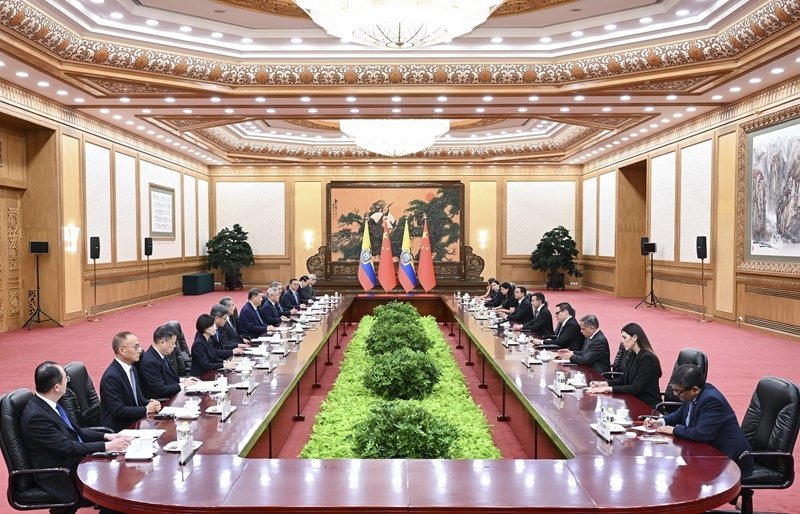 High-level diplomatic talks between Chinese and Ecuadorian delegations seated at long conference table with both nations flag