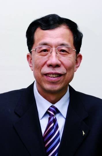 Middle-aged Asian man in black suit with purple and blue striped tie and rimless glasses, smiling in formal professional head