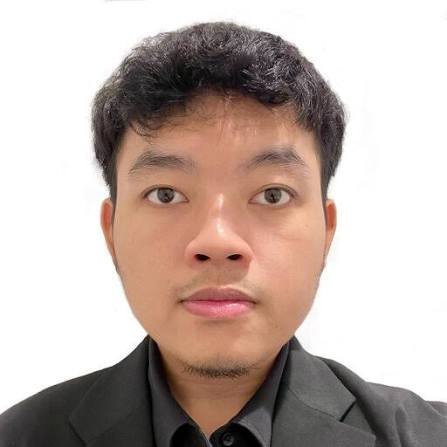 Young Asian man with short black hair and light beard wearing a dark charcoal blazer against a white background