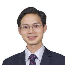 Young Asian professional man wearing rectangular glasses, dark suit jacket, and striped purple tie with a friendly smile