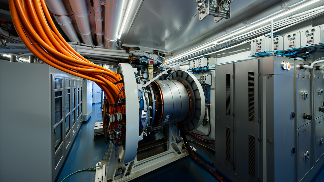 Photorealistic wide-angle view inside a modern ferry machinery room showcasing electric ship propulsion with a permanent-magnet motor, azimuth pod coupling, orange high-voltage cables, VFD cabinets, switchboard, and lithium-ion battery racks amid stainless piping and cable trays.
