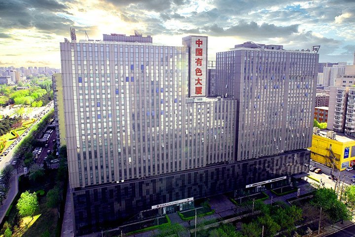 中国有色大厦 China Nonferrous Metals Building, a large modern glass office complex in Beijing with dramatic cloudy sky