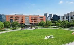 NXMTE university campus featuring large red brick academic buildings surrounded by manicured green lawn and mature trees in C