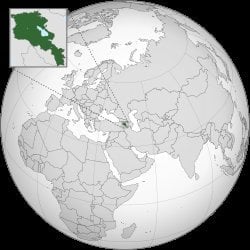 Orthographic globe map highlighting Armenia in dark green, located in the South Caucasus between Europe and Asia, with inset